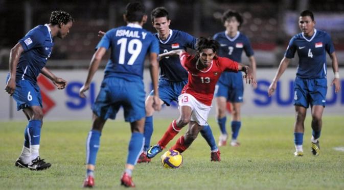 Budi Sudarsono menghindari penjagaan pemain Singapura saat penyisihan grup Piala AFF 2008 di Jakarta. (AFP/Bay Ismoyo)