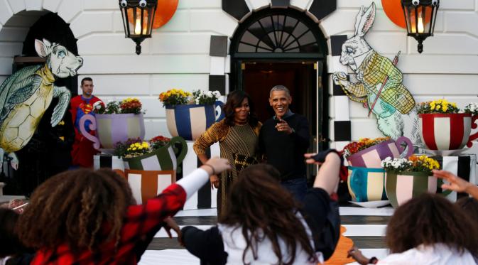 Reaksi Presiden AS, Barack Obama dan ibu negara Michelle Obama menyaksikan tarian flash mob dari anak-anak yang berdandan ala zombie saat merayakan Halloween di Gedung Putih, Washington, Senin (31/10). (REUTERS / Jonathan Ernst)