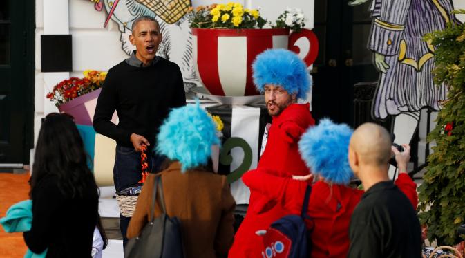Presiden Barack Obama membagikan coklat dan permen ke anak-anak saat merayakan Halloween di Gedung Putih, Washington, Senin (31/10). Sebanyak 4.000 orang diperkirakan mengunjungi White House untuk merayakan Hallowen. (REUTERS / Jonathan Ernst)