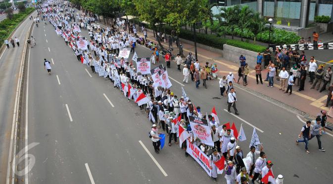 Massa aksi damai 4 November berjalan berbaris memasuki kawasan Thamrin menuju Balai Kota, Jakarta Pusat, Jumat (4/11). Demo 4 November menuntut penuntasan proses hukum Basuki Tjahaja Purnama (Ahok) ini diikuti berbagai ormas. (Liputan6.com/Angga Yuniar)