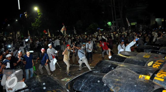 Massa Aksi Damai 4 November mencoba menerobos penjagaan dari petugas, Jakarta, Jumat (4/11). Belum diketahui apa yang menyebabkan terjadinya bentrokan dari aksi yang awalnya damai ini. (Liputan6.com/Angga Yuniar)