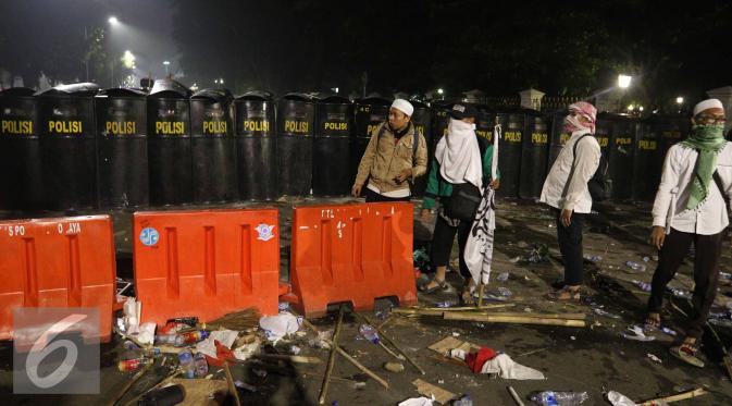 Polisi berjaga di jalan Medan Merdeka Barat saat Aksi Damai 4 November, Jakarta, Jumat (4/11). Polisi membubarkan massa dengan paksa dengan gas air mata. (Liputan6.com/Faizal Fanani)