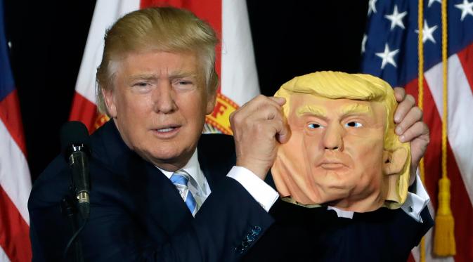 Ekspresi Donald Trump saat menunjukan topeng wajah dirinya ke awak media saat berkampanye di Sarasota, Florida, AS (7/11). Pilpres AS 2016 akan diadakan pada 8 November 2016 dan menjadi pilpres empat tahunan ke-58.  (REUTERS/Carlo Allegri) 