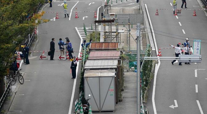 Petugas pemadam dikerahkan ke lokasi munculnya lubang raksasa atau sinkhole di persimpangan dekat Stasiun Hakata, Fukuoka, Jepang, Selasa (8/11). Insiden itu mengakibatkan lalu lintas terputus, pemadaman listrik serta kebocoran gas. (STR/JIJI PRESS/AFP)