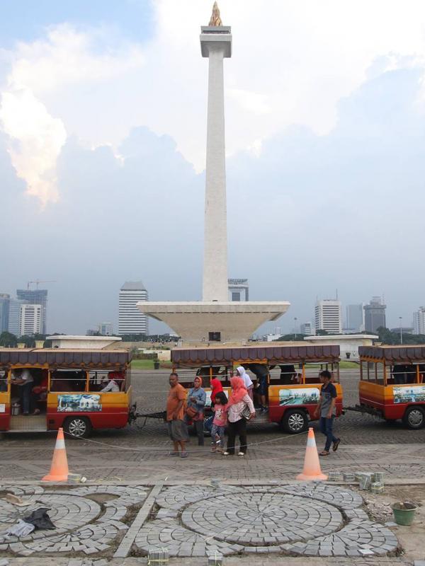 Para pekerja mengganti batu pelataran yang rusak di kawasan Monas, Jakarta, Kamis (10/11). Hal tersebut dilakukan untuk menjaga kawasan Monas agar tetap terawat dan nyaman bagi pengunjung. (Liputan6.com/Immanuel Antonius)