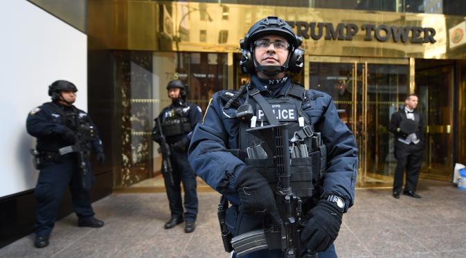 Personel NYPD berdiri di depan Trump Tower, New York, Kamis (10/11). Seiring dengan munculnya gelombang unjuk rasa anti Trump, markas Presiden terpilih AS itu kini dijaga ketat oleh sejumlah personel Departemen Kepolisian New York. (TIMOTHY A. CLARY/AFP)