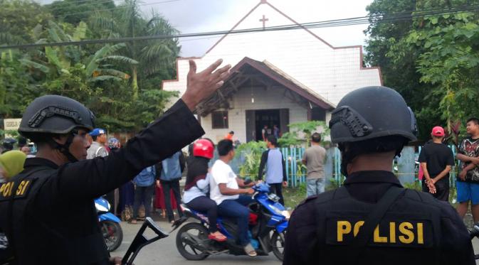 Dua petugas polisi berjaga setelah seorang pria melemparkan bom molotov ke Gereja Oikumene, Kelurahan Sengkotek, Samarinda, Kalimantan Timur, Minggu (13/11). (FIRMAN/AFP)