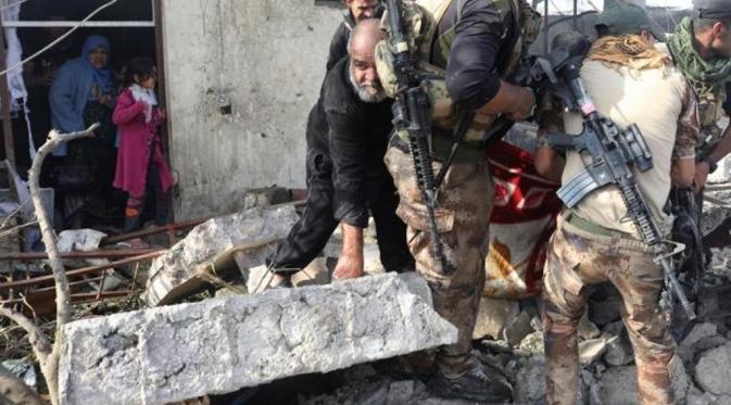 Prajurit mengangkat jasad perempuan yang menjadi korban bom bunuh diri (Reuters)