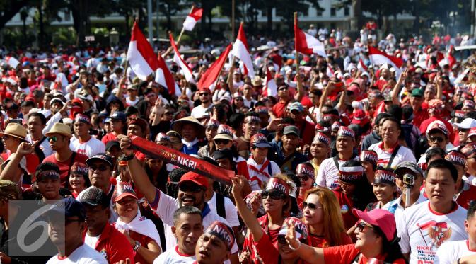 Sejumlah peserta menggunakan ikat kepala yang bertuliskan Stand of NKRI dan membawa bendera merah putih saat mengikuti aksi Parade Bhineka Tunggal Ika di kawasan Patung Kuda, Jalan MH Thamrin, Jakarta Pusat, Sabtu (19/11). (Liputan6.com/Gempur M. Surya)