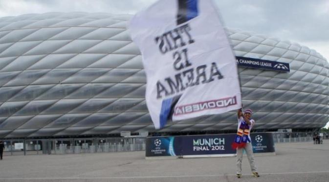 Harie Pandiono mengibarkan bendera Arema di final Liga Champions 2012. (Bola.com/Dok.pribadi)