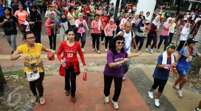 Puluhan peserta menari poco poco usai mengikuti Tolerun 2016 di kawasan Jalan Jenderal Sudirman, Jakarta, Minggu (20/11). Ratusan orang berlari merayakan toleransi keberagaman dalam Tolerun 2016. (Liputan6.com/Helmi Fithriansyah) 