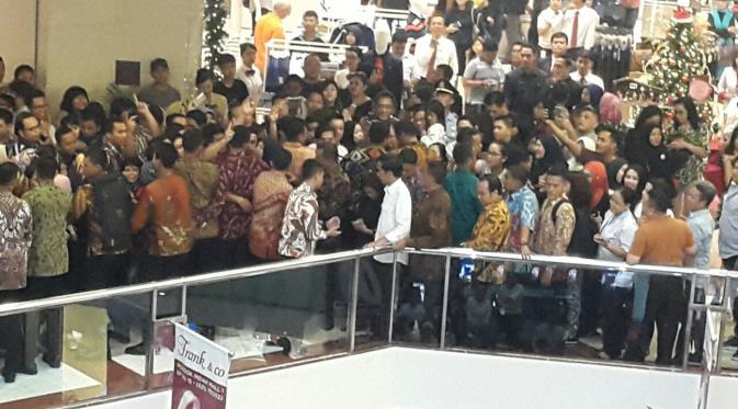 Presiden Joko Widodo dikerumuni pengunjung pusat perbelanjaan Pondok Indah Mall, Jakarta Selatan, Minggu (20/11). Kehadiran Jokowi yang dikawal sejumlah petugas Paspampres ini mengundang perhatian pengunjung mal. (Dok. Paspampres)
