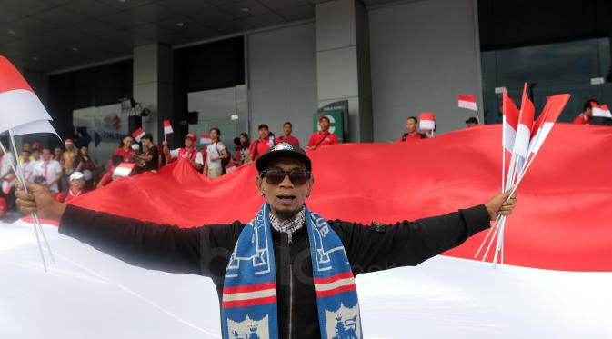Aksi Suporter Arema berbaur membentangkan bendera Merah-Putih saat memberi dukungan untuk Timnas Indonesia melawan Thailand pada laga AFF Suzuki Cup 2016 di Philippine Sports Stadium, (19/11/2016).  (Bola.com/Nicklas Hanoatubun)