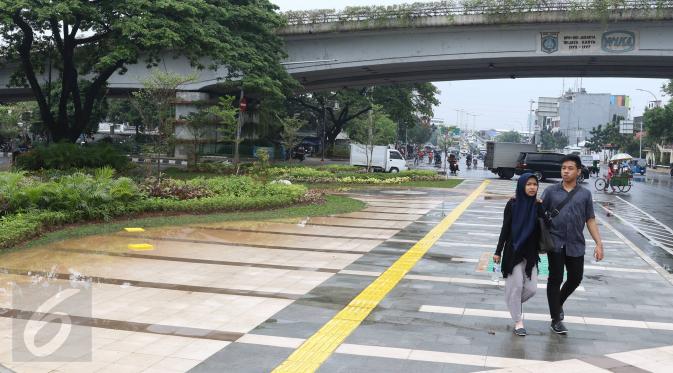 Pejalan kaki melintasi trotoar di Jalan Jatibaru Raya, Tanah Abang, Jakarta, Senin (21/11). Meskipun belum sepenuhnya selesai, namun trotoar yang dulu dipenuhi PKL tersebut kini telah berubah menjadi bersih dan asri. (Liputan6.com/Immanuel Antonius)