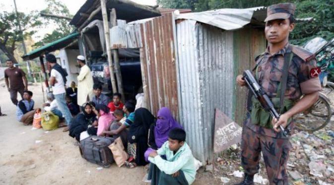 Petugas keamanan mengamankan pengungsi Rohingnya yang melintasi batas secara ilegal (21/11) (Reuters)