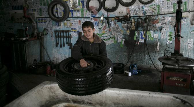 Odai Abu Matrouq (13) menyelesaikan pekerjaannya di sebuah bengkel di Rafah, Selatan Jalur Gaza, 21 November 2016. Akibat perang, kurang lebih setengah dari penduduk Gaza yang  berjumlah 1,9 juta jiwa hidup di bawah garis kemiskinan. (SAID KHATIB/AFP)