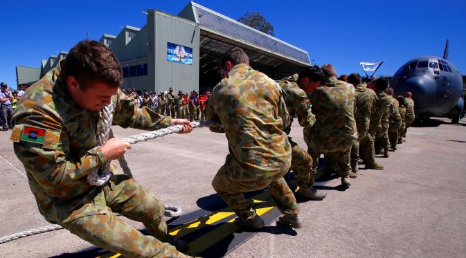 Semangat anggota Royal Australian Air Force menarik sebuah pesawat Hercules C-130J saat mengikuti lomba ketangkasan di Pangkalan Udara Richmond, Sydney (24/11). Lomba ini sebagai kegiatan melatih ketangkasan sekaligus kebersamaan. (REUTERS/David Gray)