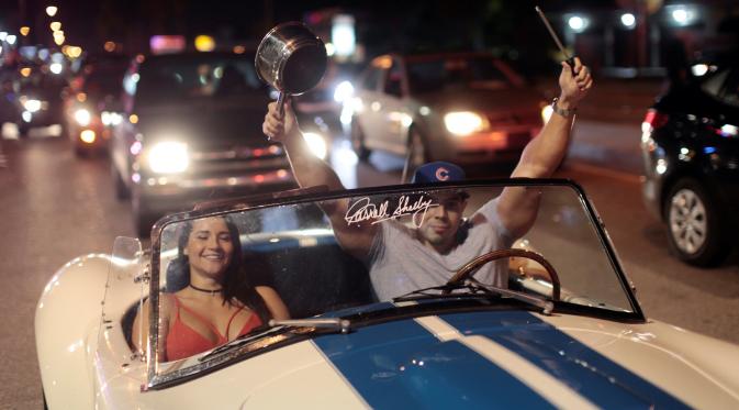 Warga Kuba berada di mobil bersorak saat turun ke jalan merayakan wafatnya Fidel Castro di Miami, AS (26/11). Wafatnya pemimpin revolusi komunis Kuba tidak ditanggapi dengan kesedihan oleh warga Kuba yang menetap di Miami. (REUTERS/Javier Galeano)