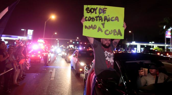 Warga Kuba bersorak saat turun ke jalan merayakan wafatnya Fidel Castro di Miami, AS (26/11). Mereka merupakan warga Kuba yang melarikan diri ke negara lain saat Castro berkuasa. (REUTERS/Javier Galeano)