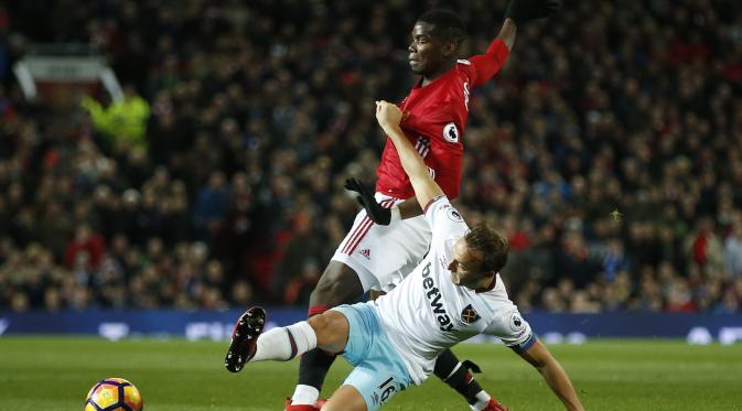 Paul Pogba melakukan diving saat berebut bola dengan pemain West Ham United, Mark Noble. (Reuters / Andrew Yates)