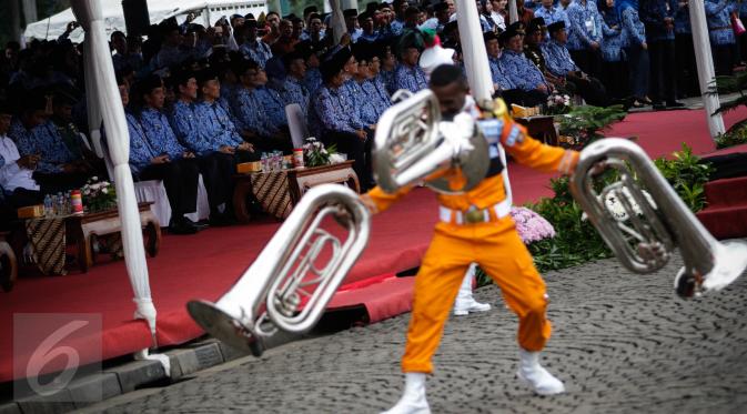 Presiden Jokowi melihat parade marching band dari IPDN pada upacara peringatan HUT Korps Pegawai Republik Indonesia (Korpri) ke 45 di Silang Monas, Jakarta,  Selasa (29/11). Presiden Jokowi bertindak menjadi Inspektur Upacara. (Liputan6.com/Faizal Fanani)
