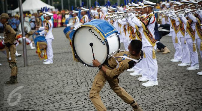 Aksi marching Band IPDN memeriahkan upacara peringatan HUT Korps Pegawai Republik Indonesia (Korpri) ke 45 di Silang Monas, Jakarta,  Selasa (29/11). Dalam upacara ini, peserta mengenakan seragam KORPRI hingga pakaian adat. (Liputan6.com/Faizal Fanani)