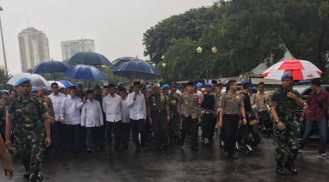 Presiden Jokowi berjalan di tengah hujan di Aksi Damai 2 Desember 2016.