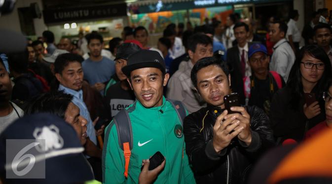 Masyarakat berselfie dengan pemain tim nasional saat tiba di Bandara Soekarno Hatta, Jakarta, Kamis (8/12). Setelah menahan imbang Vietnam pada semifinal Piala AFF 2016, Timnas pulang membawa kemenangan untuk Indonesia. (Liputan6.com/Faizal Fanani)