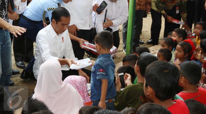 Presiden Joko Widodo (Jokowi) membagi-bagikan buku tulis untuk anak-anak saat meninjau tenda pengungsian korban gempa Aceh di Pidie Jaya, Jumat (9/12). Selain buku tulis, Jokowi juga membagikan kotak pensil kepada warga. (Liputan6.com/Angga Yuniar)