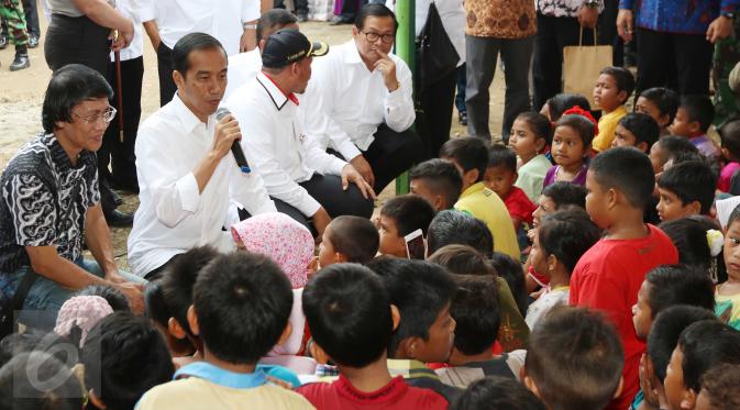 Presiden Joko Widodo (Jokowi) berdialog dengan para anak saat meninjau tenda pengungsian korban gempa Aceh di Pidie Jaya, Jumat (9/12). Dalam kunjungan tersebut, Jokowi membagikan buku tulis untuk anak-anak. (Liputan6.com/Angga Yuniar)