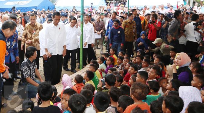 Presiden Joko Widodo (Jokowi) bersama Ketua Lembaga Perlindungan Anak Indonesia (LPAI) Seto Mulyadi (jongkok) menghibur para anak korban gempa Aceh di posko pengungsian di Pidie Jaya, Jumat (9/12). (Liputan6.com/Angga Yuniar)