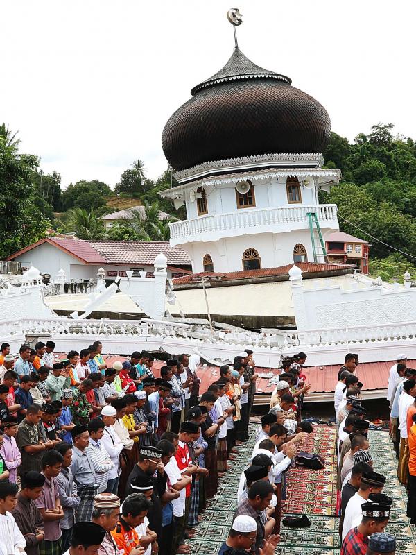 Sejumlah warga melaksanakan Salat Jumat di halaman Masjid Jami Quba, Pidie Jaya, Aceh, Jumat (9/12). Gempa berkekuatan 6,5 SR telah merobohkan ratusan bangunan termasuk Masjid Jami Quba. (Liputan6.com/Angga Yuniar)