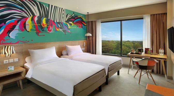Pola dedaunan, struktur dan ranting pohon serta tekstur kayu berwarna hangat membuat suasana kamar hotel menjadi semarak.