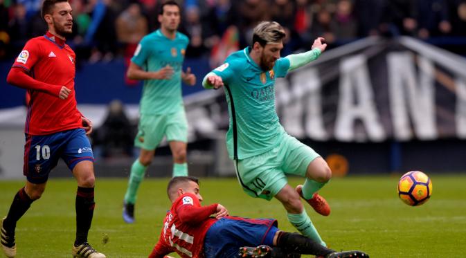 Lionel Messi mencoba melewati adangan pemain Osasuna. (Reuters/Vincent West)