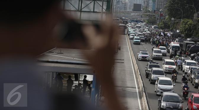Sejumlah kendaraan terjebak kemacetan saat berlangsungnya sidang perdana Basuki Tajahaja Purnama (Ahok) di eks PN Jakarta Pusat, Selasa (13/12). Arus lalulintas depan pengadilan dipadati kendaraan petugas dan pengunjung sidang (Liputan6.com/Faizal Fanani)