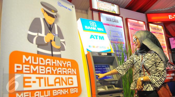 Seorang wanita membayar denda tilang dengan sistem tilang elektronik atau e-tilang melalui mesin ATM BRI di Jakarta, Jumat (16/12). e-Tilang adalah sistem aplikasi pembayaran denda tilang melalui sistem e-banking atau ATM. (Liputan6.com/Angga Yuniar)