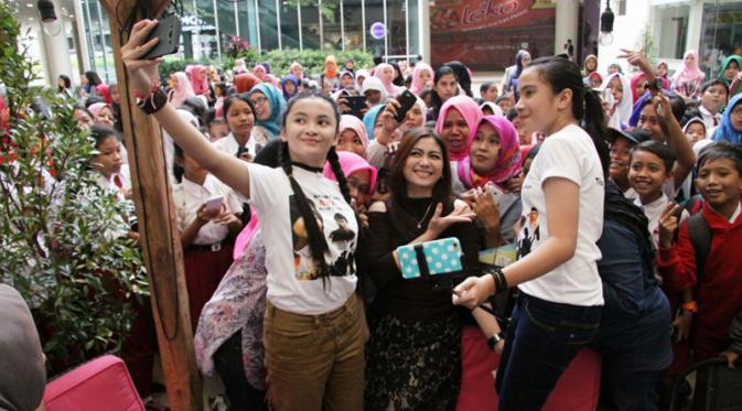 Dua bintang cilik pemeran film Ayu Anak Titipan Surga, Luthfiyah Putri dan Zila Zafila melakukan foto bersama dengan penonton di acara nonton bareng film tersebut. (Istimewa)