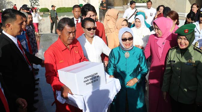 Menteri Yohana Yembise dan Ibu Wapres, Mufidah Jusuf Kalla memberikan bantuan dan apresiasi pada para petugas di Taman Makam Pahlawan Kalibata, Jakarta, Selasa (20/12).