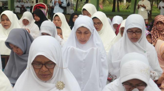 Warga Aceh yang berziarah di kuburan massal menggelar doa dan membaca Yasin bersama. (Liputan6.com/Windy Phagta)
