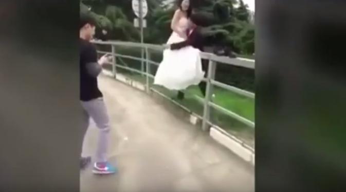 Tak sengaja terpeleset saat jalan di atas pagar, foto pengantin gagal keren dan malah bikin ngilu. (Foto: mirror.co.uk)