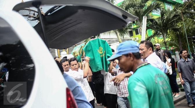 Keranda jenazah korban pembunuhan sadis Pulomas dimasukkan ke ambulan usai disalatkan di Masjid At Taubah, Pulomas, Kayuputih, Jakarta, Rabu (28/12). Tiga jenazah akan dibawa menuju TPU Tanah Kusir untuk dimakamkan. (Liputan6.com/Faizal Fanani)