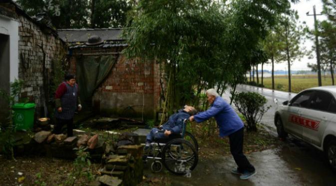 Walaupun sudah berusia 80 tahun, selama 50 tahun terakhir ini seorang ayah masih terus tabah merawat anaknya yang menderita polio. (Sumber Tencent)