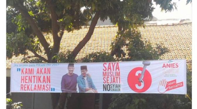 Sebuah spanduk yang memasang foto Anies-Sandi beredar dengan tulisan yang memuat tulisan 