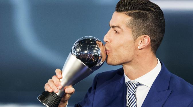 Cristiano Ronaldo mencium trofi penghargaan pemain terbaik FIFA 2016. (Ennio Leanza/Keystone)