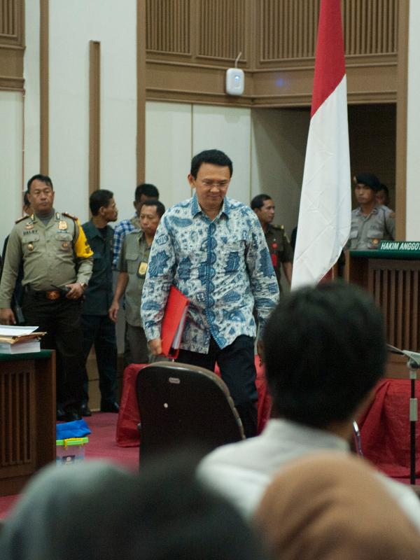 Basuki Tjahaja Purnama (Ahok) berjalan menuju kursi terdakwa untuk menjalani sidang lanjutan di Auditorium Kementan, Jakarta Selatan, Selasa (10/1). Ahok yang langsung masuk ke ruang sidang terlihat menenteng map merah. (Liputan6.com/Hendra Setyawan/Pool)