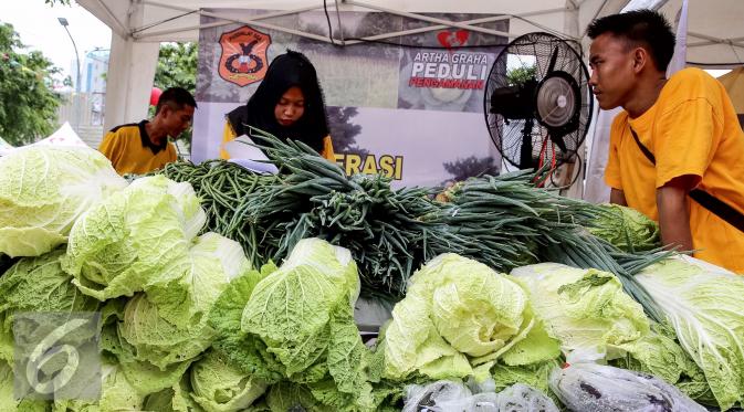 Pedagang menjual sayur mayur pada acara kick off pasar murah di Kawasan SCBD, Jakarta (14/1). Kegiatan ini juga digelar di sejumlah provinsi Banten, Surabaya, Manado, Makasar, Bali, Samarinda, Bandung, Semarang, dan Medan. (Liputan6.com/Fery Pradolo)