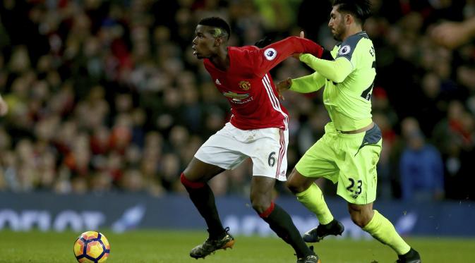 Gelandang Manchester United (MU), Paul Pogba sedang berduel dengan pemain Liverpool, Emre Can. (AP Photo/Dave Thompson)