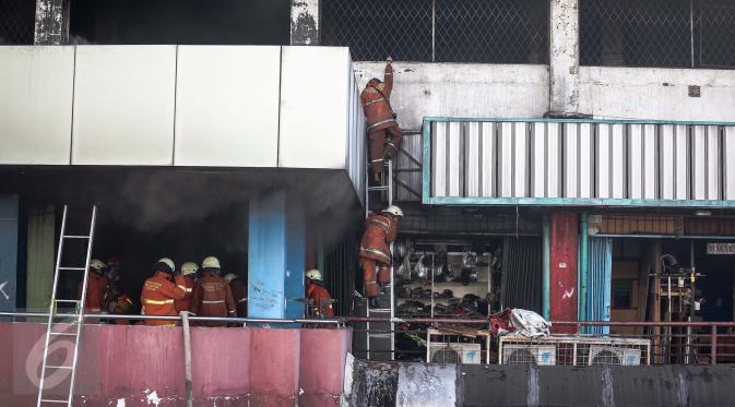 Petugas pemadam kebakaran berjibaku melakukan pemadaman di Pasar Senen, Jakarta Pusat, Kamis (19/1). Petugas kesulitan memadamkan api karena banyaknya bahan yang mudah terbakar dan sulitnya petugas menjangkau titik api. (Liputan6.com/Faizal Fanani)