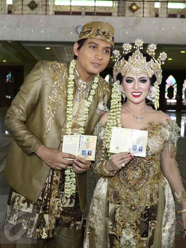 Lucky Hakim dan Tiara Dewi menunjukkan buku nikah seusai akad nikah di Masjid At Tin, Jakarta, Kamis (19/1/). Pernikahan Lucky dan Tiara berlangsung sederhana dan tak banyak kerabat dan tamu undangan yang hadir. (Liputan6.com/Herman Zakharia)