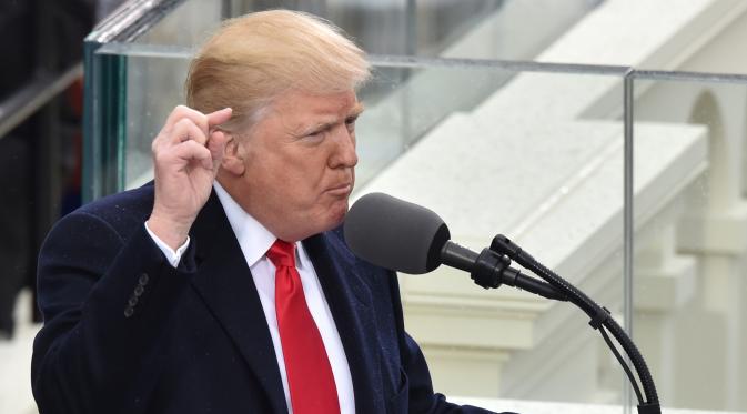 Donald Trump menyampaikan pidato pertamanya usai dilantik menjadi presiden di Capitol Hill, Washington DC, AS, Jumat (20/1). Menurut Trump pergantian presiden adalah mentransfer kekuatan dari Washington DC kepada warga AS. (AFP Photo)
